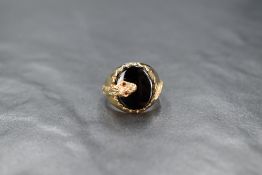 A 9ct gold signet ring having oval jet panel with serpent decoration, size M & approx 4.2g