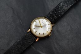 A gent's 1970's 9ct gold wrist watch by Garrard having a baton numeral dial on a pearlised face in a