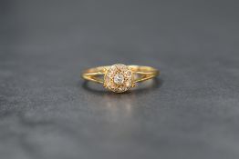 A 1920's 18ct gold diamond cushion cluster ring having a central diamond with surrounding old cut