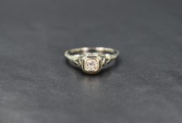 An early 20th century white gold diamond solitaire ring stamped 18K, the stone approx 0.25ct in a