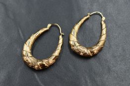 A pair of 9ct gold hoop earrings, the oval hoops having twisted alternating plain and textured