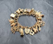 A 9ct gold charm bracelet having padlock clasp and 26 charms including bagpipes, £10 emergency