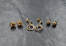 A pair of 9ct two tone gold drop earrings, the openwork yellow gold circle enclosing a further white