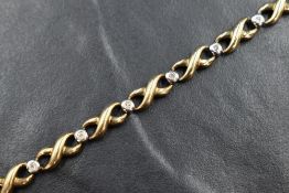 A 9ct gold diamond infinity motif bracelet, the infinity style links interspersed with bezel set