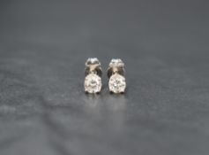 A pair of 18ct white gold diamond solitaire stud earrings, the round brilliant cut diamonds