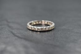 A high carat white gold diamond eternity band, having round cut illusion set diamonds to the
