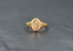 A 9ct gold signet ring, the oval panel having scroll engraving to one end, ring size O-P, 2.9g