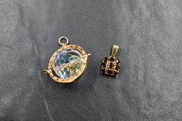 A 9ct gold garnet pendant, the central round cut garnet with an eight round cut garnet square