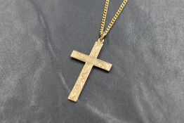 A 9ct gold cross having engraved scroll decoration on a yellow metal chain bearing mark SPAIN18, 24'