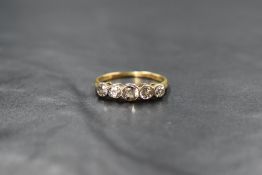 An 18ct gold five stone diamond ring, the old cut graduated diamonds in collared mounts, approx 1.