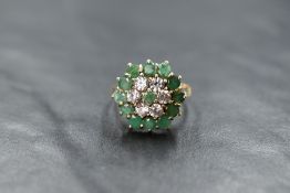 A 9ct gold triple cluster ring having cubic zirconia and emerald style stones in a claw set basket