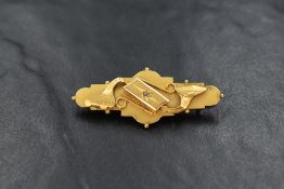 A 9ct gold and diamond brooch, the matte finish bar brooch having a central set diamond chip with