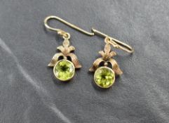 A pair of 9ct gold loop drop earrings having circular green stones in collared mounts from bow