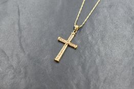 An 18ct gold diamond set cross pendant, the cross having an central diamond measuring