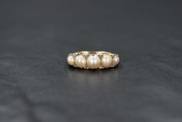 A yellow metal presumed gold pearl and diamond five stone ring, the five graduated split pearls of