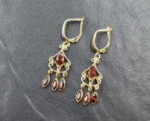 A pair of 9ct gold chandelier style earrings having clip loop fastenings and red/orange coloured