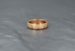 A 9ct gold band, having decorative engraving and bead thread, ring size P, 1.8g