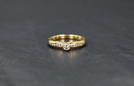 An 18ct gold diamond solitaire ring, the bezel set round brilliant cut diamond measuring