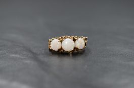A 9ct gold opal trio ring having three circular opal cabochons in a claw set naturalistic mount on a