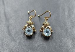 A pair of 9ct gold loop drop earrings having circular aqua marine stones in collared mounts from bow