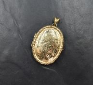 A 9ct gold oval locket having engraved scroll effect decoration and a moulded border, approx 17.3g