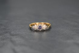 An Edwardian yellow metal sapphire and diamond chip ring stamped 18ct having a central powder blue