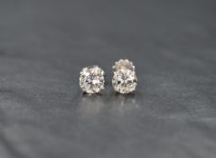 A pair of 14ct white gold diamond solitaire stud earrings, the round brilliant cut diamonds