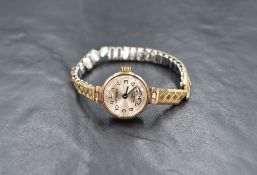 A lady's 19970's 9ct gold wrist watch by Excalibur having an Arabic numeral dial to circular face in