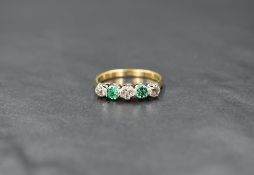 An 18ct gold emerald and diamond half eternity band, the three old cut diamond interspersed with two