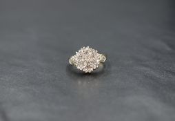 A 9ct gold multi stone diamond chip cluster in a cushion mount with diamond set shoulders, size