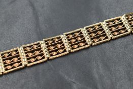A 9ct gold seven bar gate bracelet having twist bar decoration and a padlock clasp, approx 185mm &