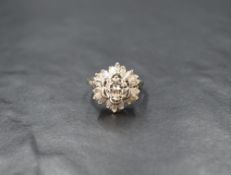 An open diamond cluster ring having a central brilliant cut diamond, approx 1ct within a frilled