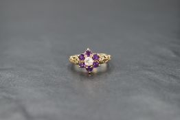 A 9ct gold white sapphire and amethyst cluster ring, the central round cut white sapphire with a six