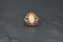 An opal ring having an oval cabochon stone in a collared decorative mount on rose gold loop, no