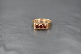 A 9ct gold garnet trilogy ring having a claw set mount in a box style setting, size N & approx 2.4g