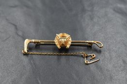 A 9ct gold hunting bar brooch modelled as a riding crop with central fox head and horse shoe, approx