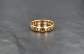 A 9ct gold wedding band having inset ruby flanked by two diamond chips in star settings, size V &