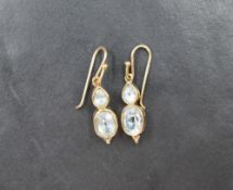 A pair of 9ct gold of loop drop earrings having aqua marine double stone drops in collared mounts,