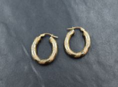 A pair of 9ct gold oval hoop earrings having etched stripe decoration, approx 1.7g