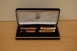 A boxed Buckingham Palace cartridge fill fountain pen and ballpoint pen set in honey brown with gold