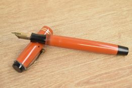 A Parker Duofold Senior button fill fountain pen in orange with two gold bands to the cap having 14K