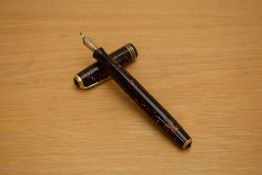 A Parker Vacumatic fountain pen in burgundy pearl with three narrow gold cap rings having a 14K