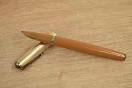 A Parker 51 vacumatic fill fountain pen in mustard with a rolled gold cap . A rare pen worth