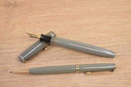 A Parker Duofold Victory button fill fountain pen and propelling pencil in grey with two gold cap