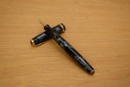 A Parker Duofold button fill fountain pen in black pearl marble with chevron gold cap band having
