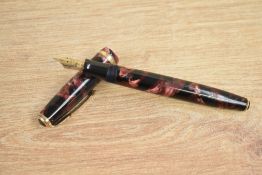 A Parker Duofold button fill fountain pen in burgundy and black pearl with single gold band to the