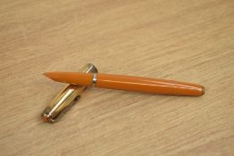 A Parker 51 vacumatic fill fountain pen in mustard with a rolled gold cap with blue diamond clip.