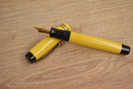 A Parker Duofold Junior button fill fountain pen in Mandarin Yellow with two gold bands to the cap