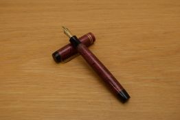 A Parker Duofold Junior button fill fountain pen in red and black herringbone pattern with two