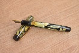A Parker Duofold Special button fill fountain pen in black and pearl with two gold bands to the